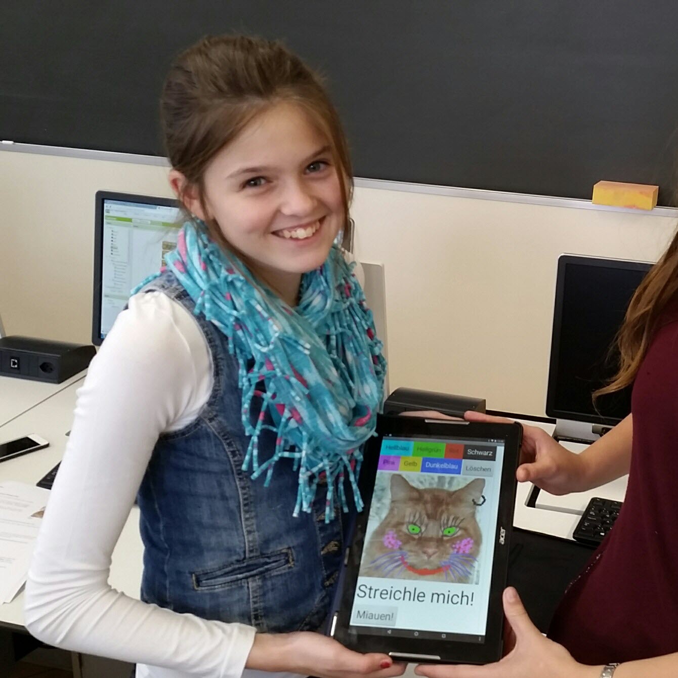 Foto: Mädchen zeigt stolz ihre selbst programmierte 
                        App zum Zeichnen auf Bildern