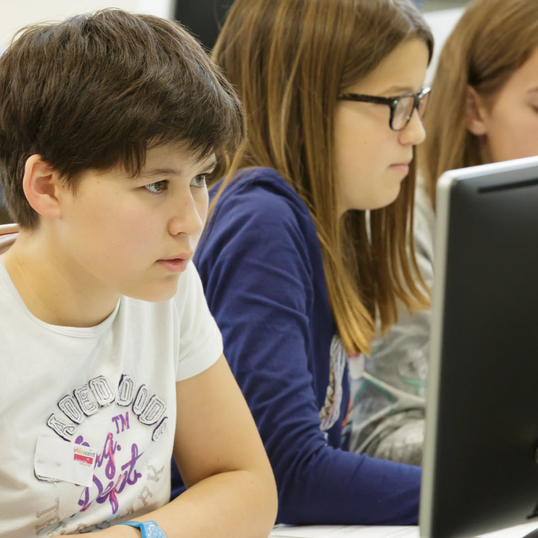 Foto: zwei Mädchen sitzen vor dem PC und 
                        programmieren mit Blöcken die Foto Mal-App