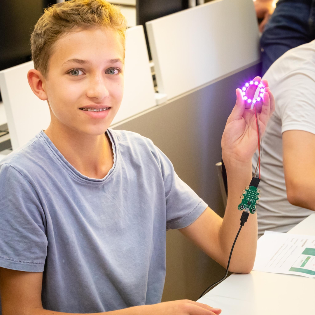 Foto von der Herstellen des LightBags: 
                        strahlender Knabe hält leuchtenden LED-Ring in der Hand